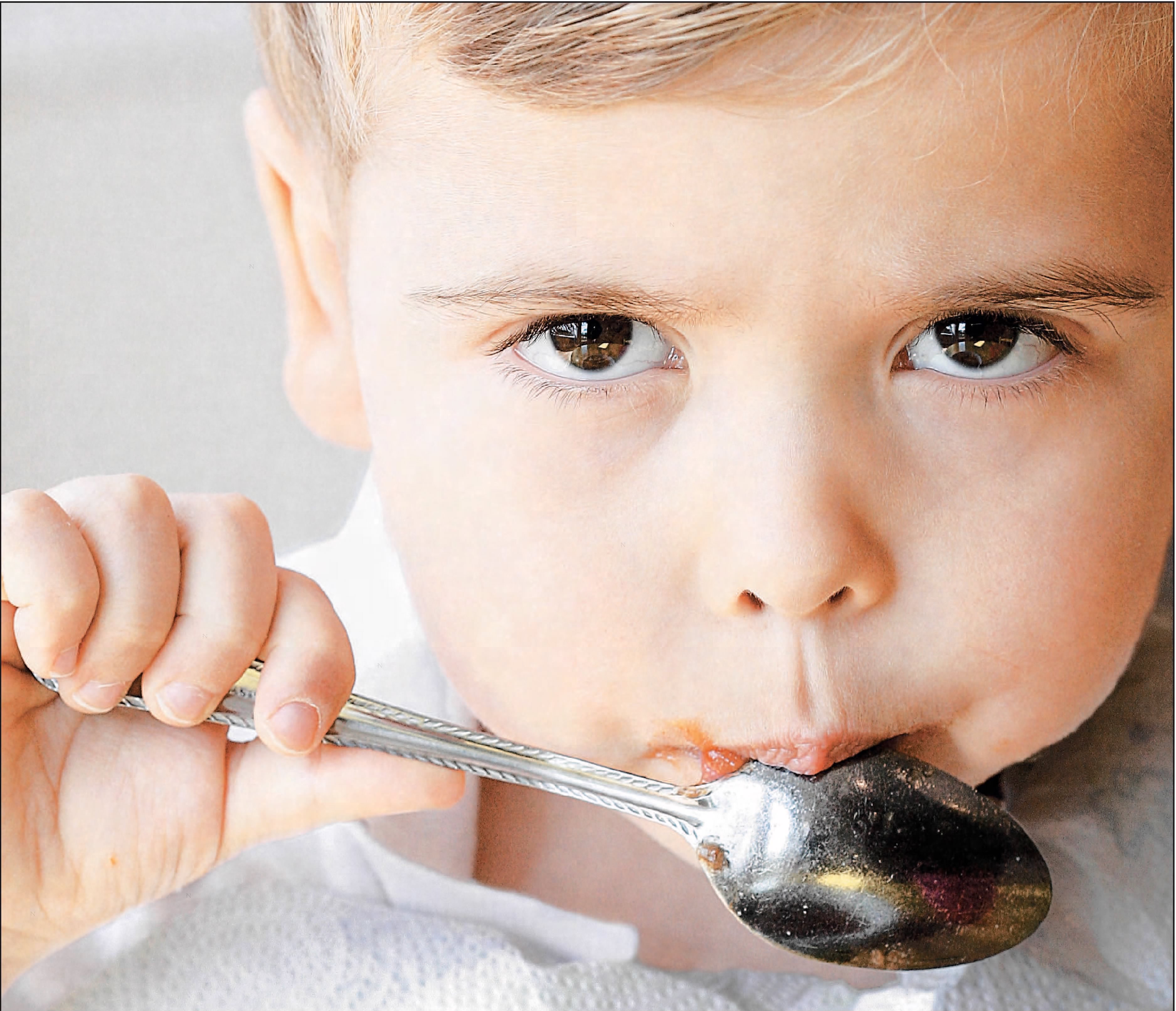 child with spoon in mouth